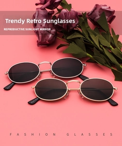 Detail view of oval metal sunglasses in gold and silver finish with dark lenses