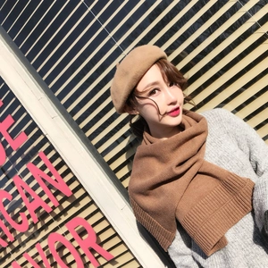Detail of khaki knit scarf and classic wool beret on model for autumn chic style