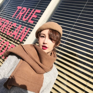 Detail shot of thick knit texture and camel brown fabric on scarf and beret