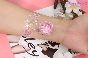 Cosmetic glitter gel arm swatch showing mixed pink and gold sequins in a clear pot