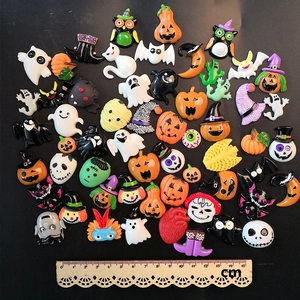 Flat lay macro of assorted Halloween resin charms including pumpkins and ghosts