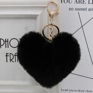 Close-up of a heart-shaped black faux fur keychain with premium gold metal hardware