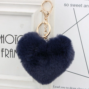 Close-up of heart-shaped faux fur keychain in deep blue with gold metal hardware and ring