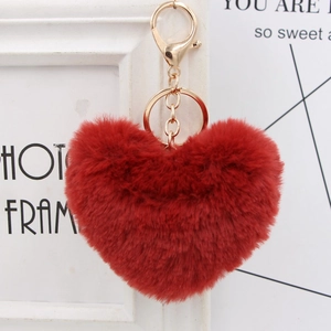 Close-up of fluffy red heart-shaped plush keychain with a premium golden metal hook