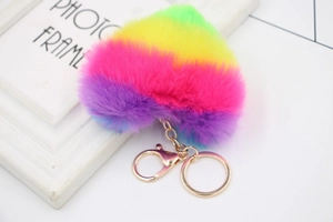 Detail of a rainbow heart plush keychain with soft gradient faux fur and gold metal chain