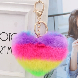 Rainbow heart plush keychain with gold metal clasp on decorative white frame