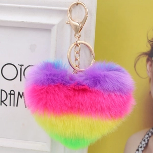 Close-up of fluffy rainbow heart keychain with a golden metal hook and ring