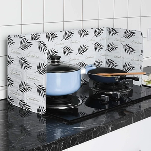 Foldable aluminum foil splash guard with leaf pattern on a kitchen countertop