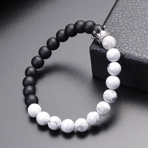 Detail of 8mm white turquoise and matte black stone beads with a silver crown charm