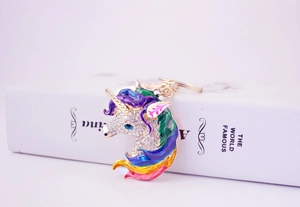 Close-up of golden unicorn keychain with colorful enamel and sparkling rhinestones