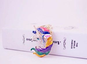 Detailed macro view of gold unicorn keychain with colorful enamel mane and rhinestones