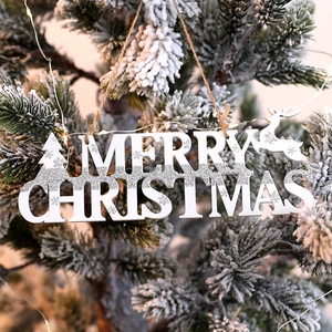 White wooden Merry Christmas sign with silver glitter and reindeer hanging on a tree