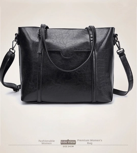 Détail latéral d'un sac cabas noir en similicuir avec coutures en U et accessoires en métal