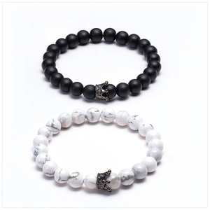Detailed macro view of lava stone and white turquoise crown bracelets on white background