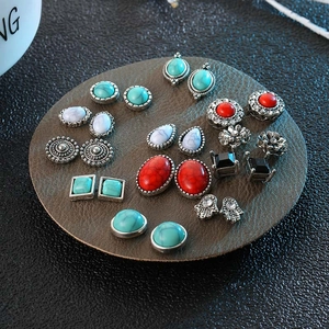 Detail of vintage turquoise and metal stud earring set on a brown leather display pad