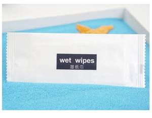 Close-up of a single wet wipe packet on blue sand, featuring the wet wipes label clearly