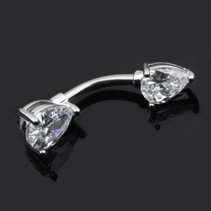 Macro shot of silver belly ring featuring two pear-cut cubic zirconia on a black surface