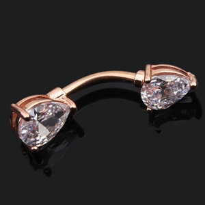 Macro shot of rose gold navel ring with pear-cut cubic zirconia on black background