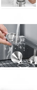 Detail of stainless steel kitchen funnel under running water showing easy cleaning feature