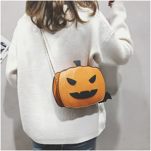 Chic pumpkin crossbody bag with bat wings and gold chain on model in white sweater