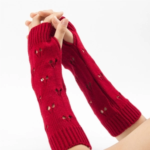 Close-up of red knit arm warmer featuring a unique hollow heart pattern and fingerless design
