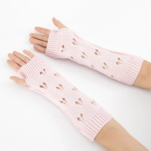Detail view of pink knitted arm warmers featuring heart-shaped cutout and fingerless style