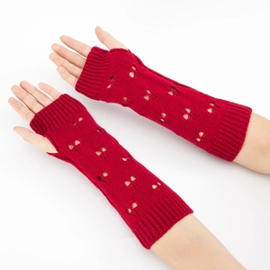 Close-up of red knit arm warmers with heart cut-out detail and thumb holes