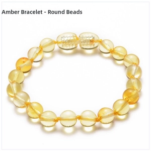 Flat lay of a golden Baltic amber beaded bracelet with clear texture on white background