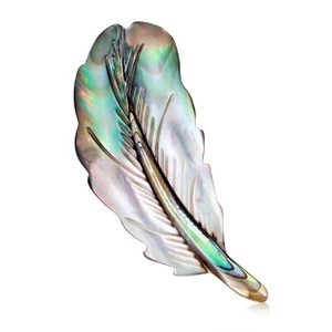 Macro detail of butterfly brooch showing natural iridescent abalone shell texture on feathers