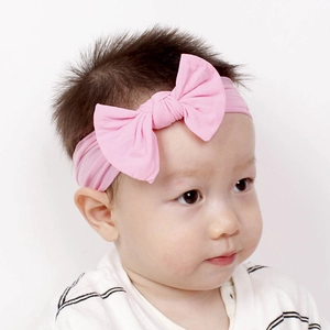 Vista dettagliata di un neonato che indossa una fascia in nylon rosa con fiocco