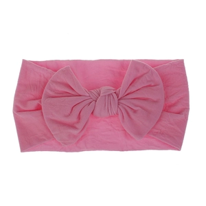 Primo piano di una fascia elastica per neonati in nylon rosa morbido con fiocco