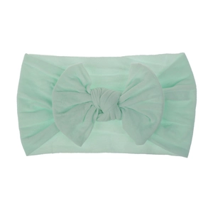 Dettaglio della fascia per neonati in nylon verde menta con grande fiocco e trama elastica