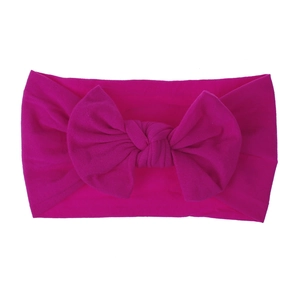 Dettaglio macro della fascia per neonati in nylon morbido con fiocco rosa acceso