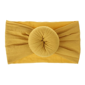 Dettaglio della fascia per neonati in nylon giallo senape con nodo a forma di donut