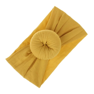 Dettaglio della fascia per neonati in nylon giallo con morbido nodo a forma di donut