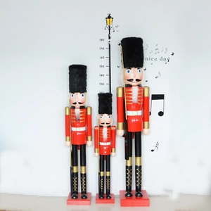 Three oversized wooden nutcracker soldier statues in red uniforms, heights up to 180cm