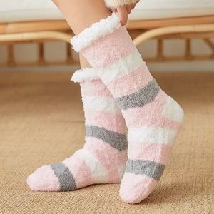 Pink and grey striped coral fleece floor socks for women in cozy home setting