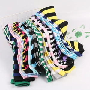 Colorful striped over-the-knee cotton socks neatly stacked in a white metal basket