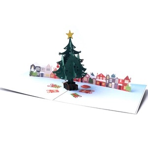 3D pop-up Christmas card featuring a green tree and colorful houses on white background