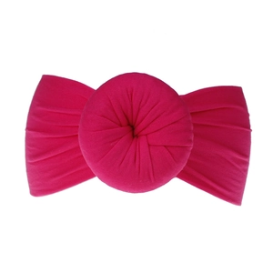 Dettaglio fascia per neonati in nylon rosso rosa con nodo a ciambella e trama elastica