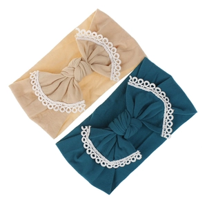 Detail of soft nylon baby headband set featuring large bows with delicate lace trim