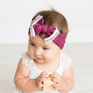 Infant soft purple nylon headband featuring a stylish large bow with white lace trim.