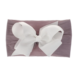 Nahaufnahme eines weichen Nylon-Babystirnbandes mit einer großen weißen Schleife.