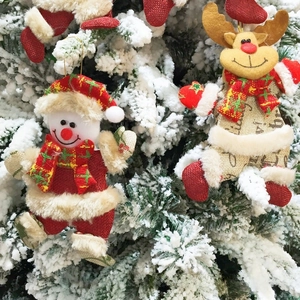 Detail von Plüsch-Weihnachtsanhängern mit Rentier und Schneemann an einem Tannenbaum