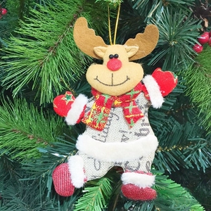 Detail eines Stoff-Rentiers mit Karoschal an einem grünen Weihnachtsbaum hängend