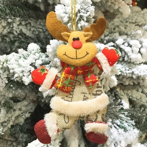 Detail eines Plüsch-Rentiers mit rotem Schal an einem verschneiten Weihnachtsbaumzweig