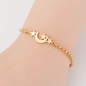 Nahaufnahme eines goldfarbenen Stern-Mond-Armbands mit einer polierten O-Gliederkette