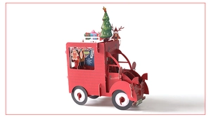 Macro shot of a 3D pop-up Christmas truck card with miniature trees and reindeer
