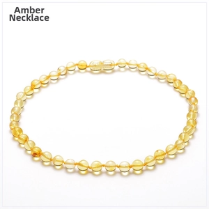 Detailed view of natural gold amber necklace with round beads and translucent finish