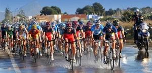 Action shot of cycling sunglasses worn by pro athletes on a wet competition road